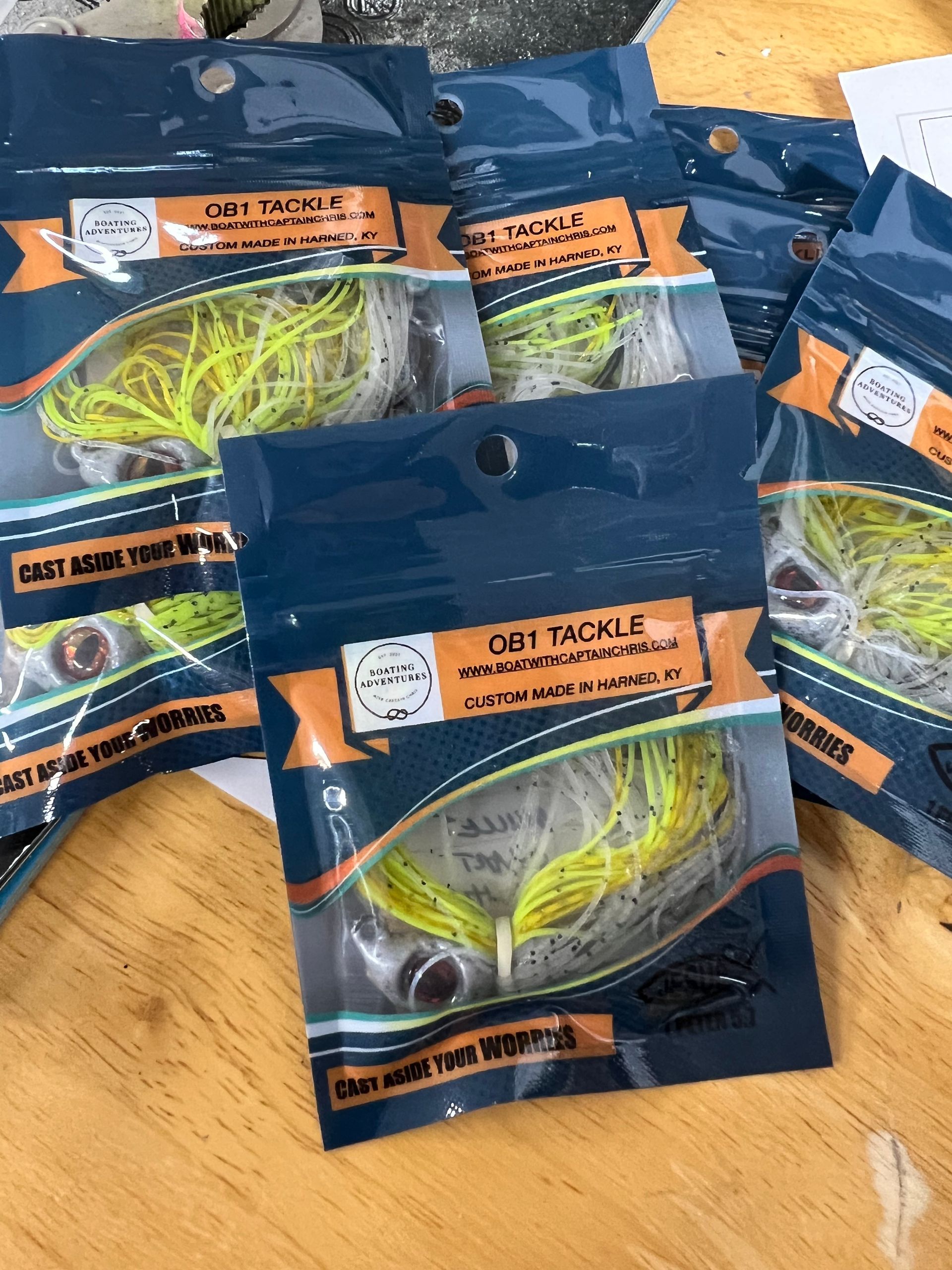 Rows of custom fishing lures in brown, green, and blue, displayed under 