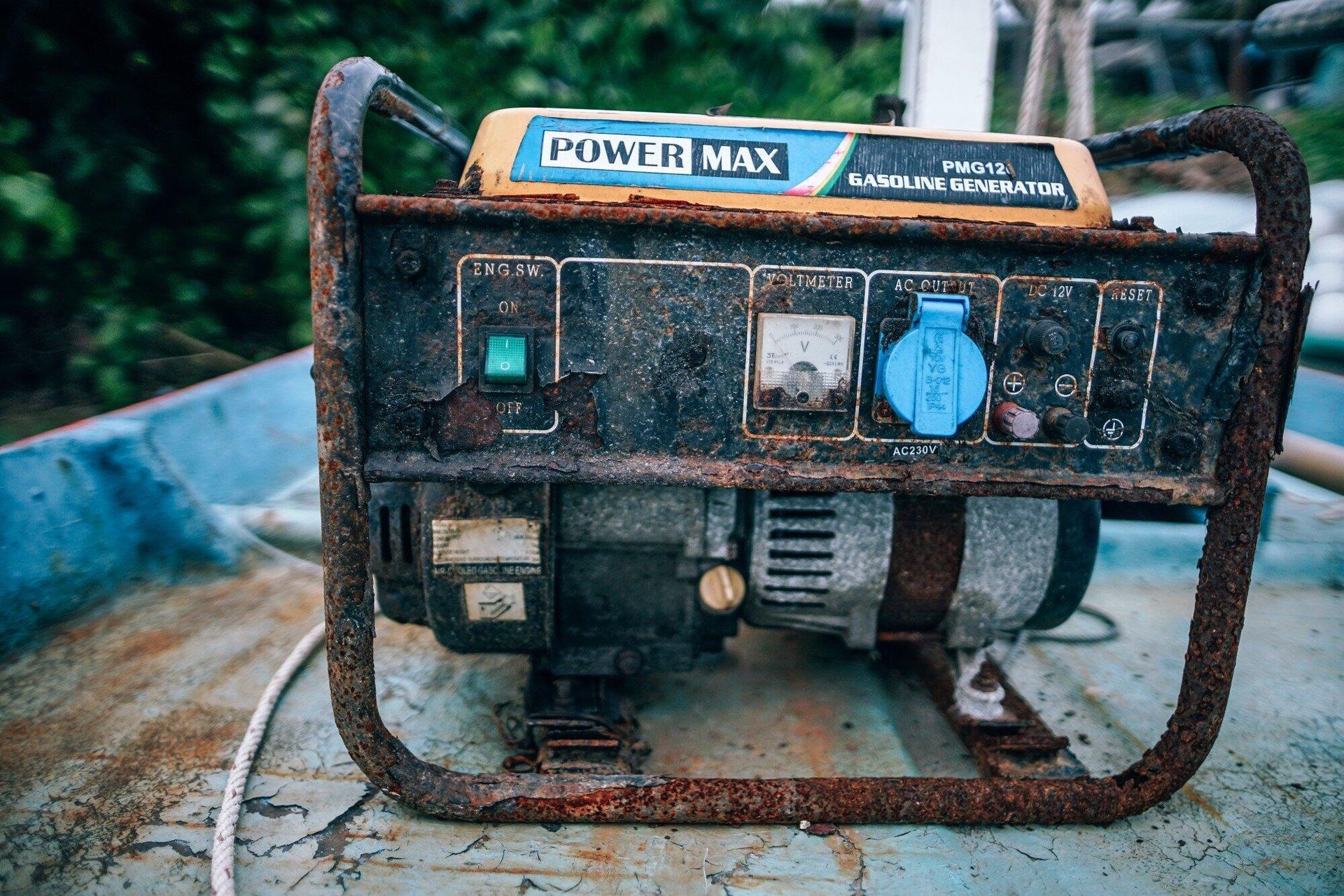 A rusty generator is sitting on top of a blue boat.