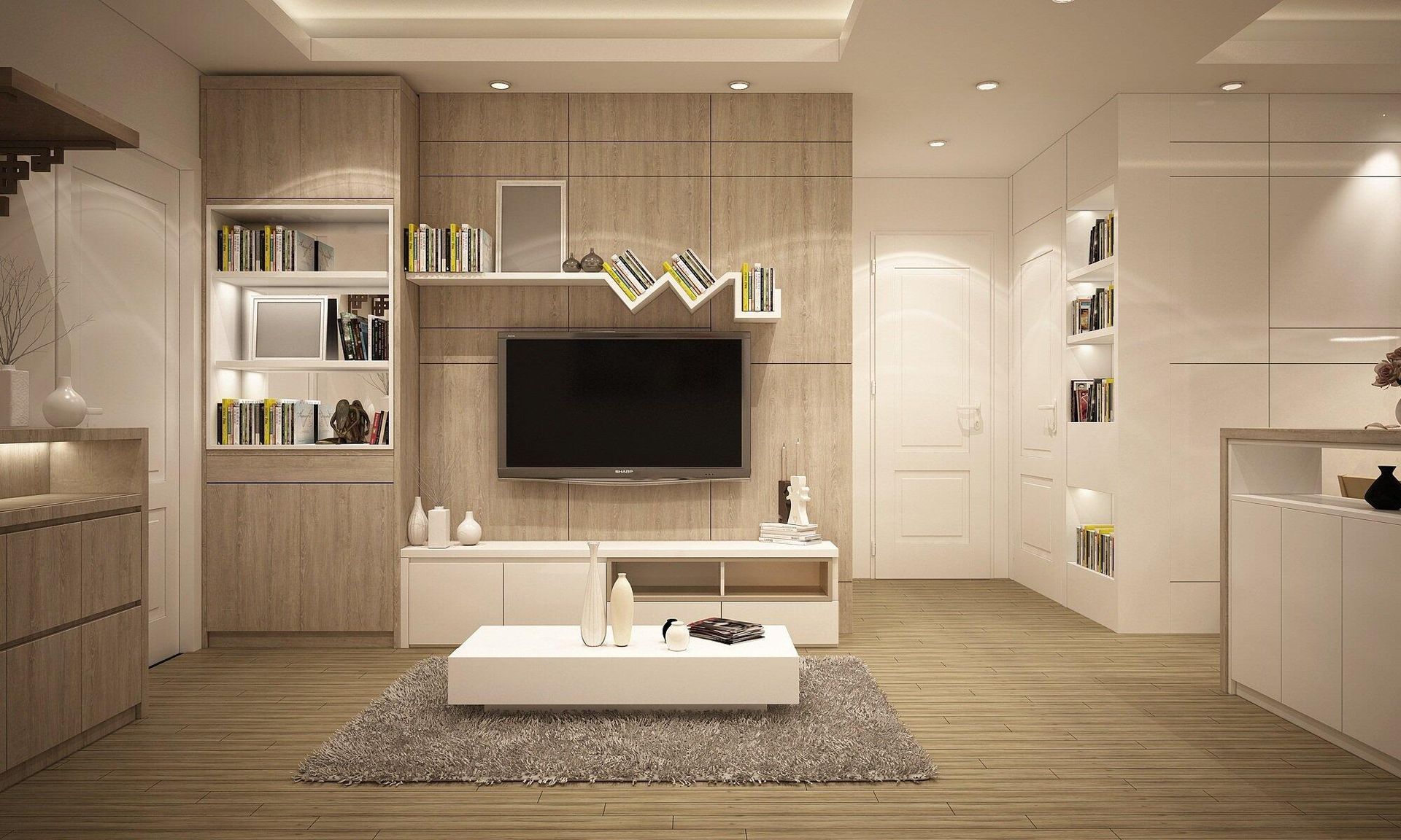 A living room with a flat screen tv on the wall and a coffee table.