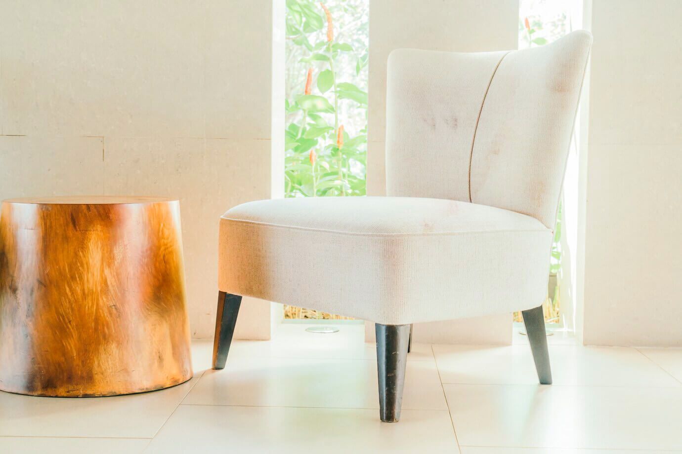 Una silla blanca está junto a una mesa de madera en una habitación.