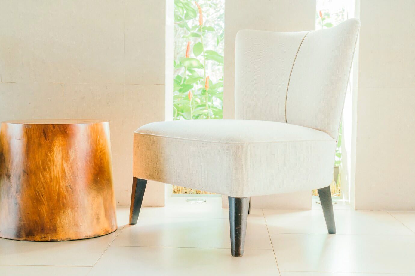 Una silla blanca está junto a una mesa de madera en una habitación.