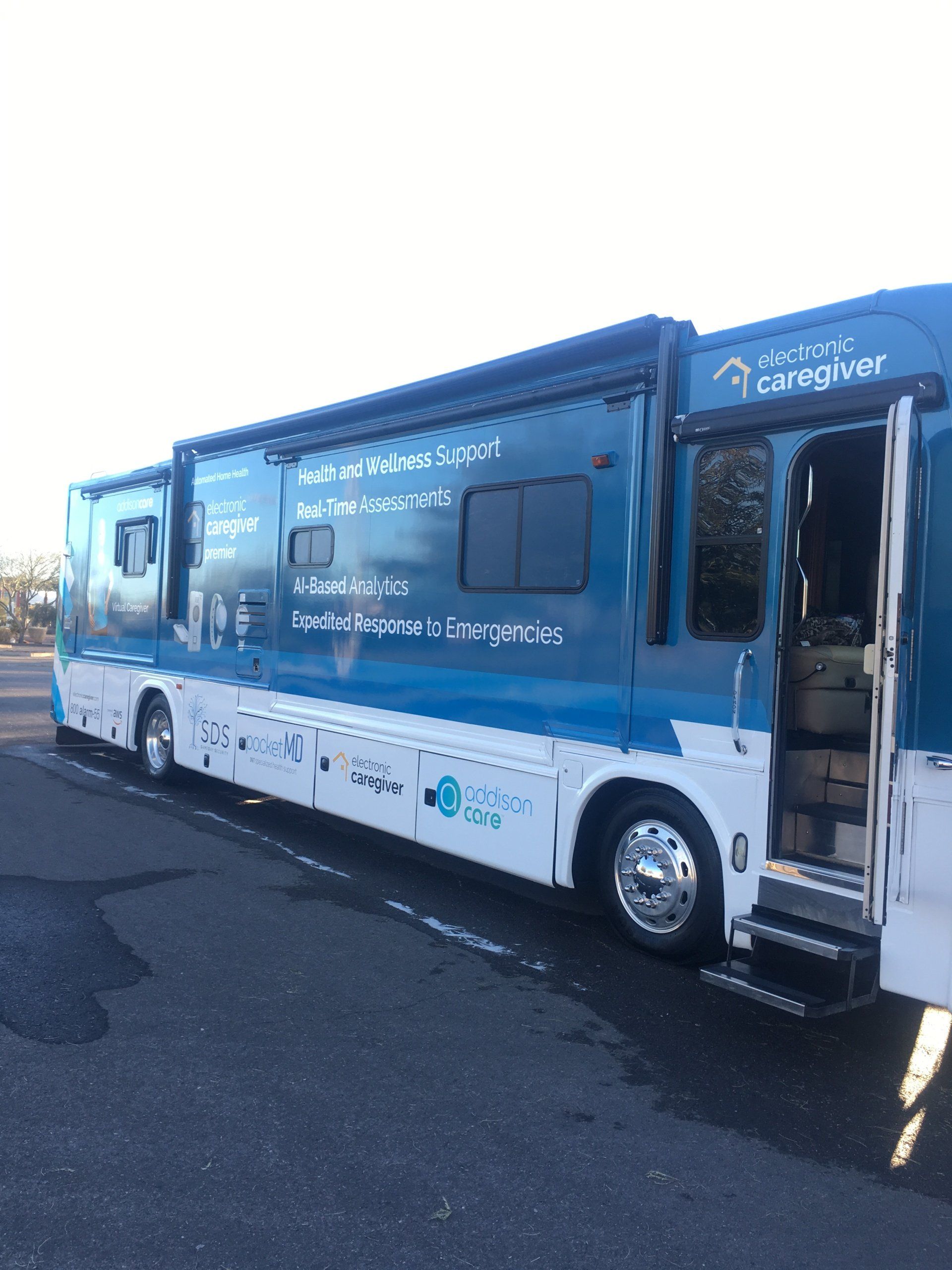 A blue and white bus is parked on the side of the road.