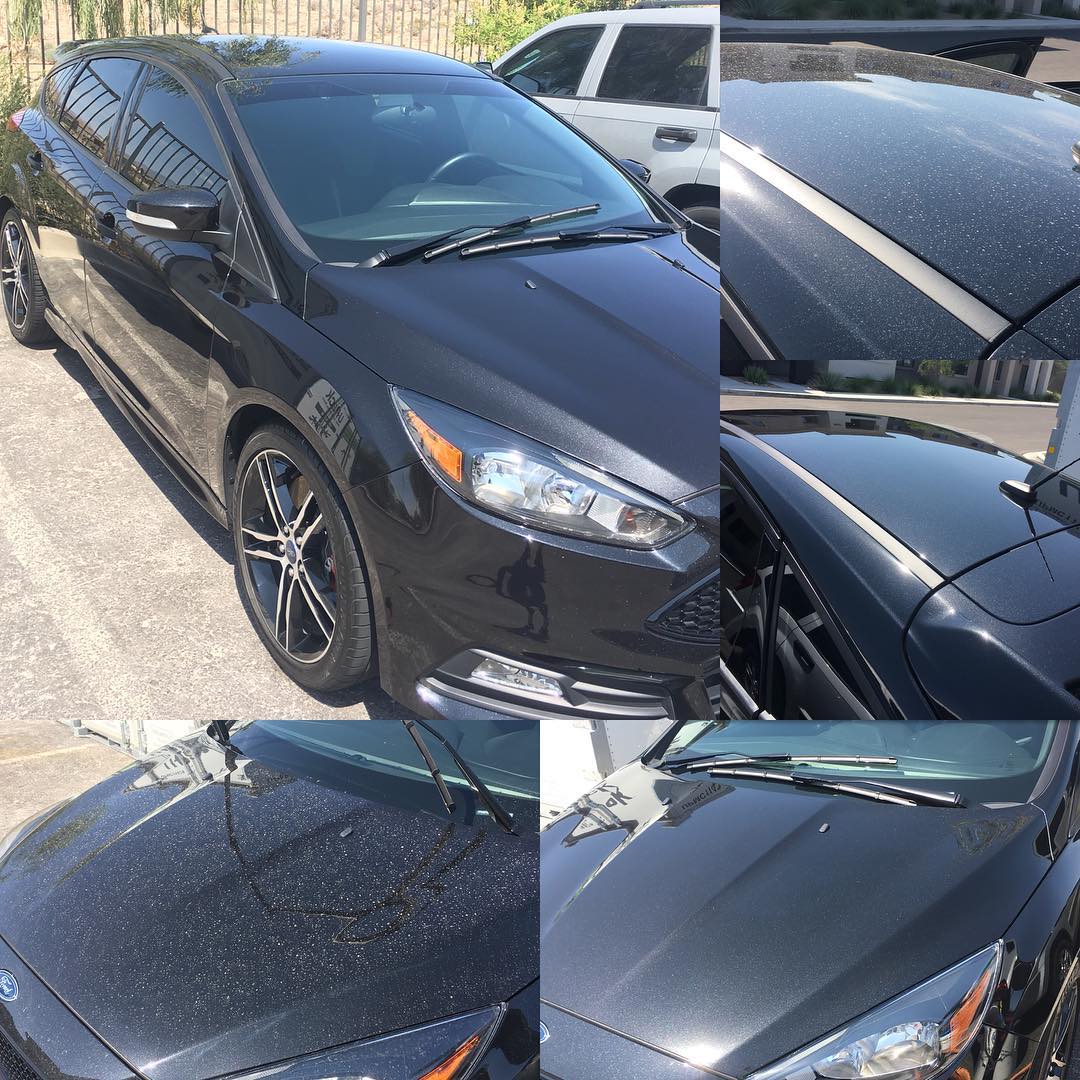 A black ford focus is parked in a parking lot.
