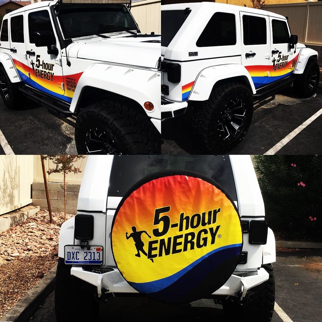 A white jeep with a tire cover that says 5 hour energy