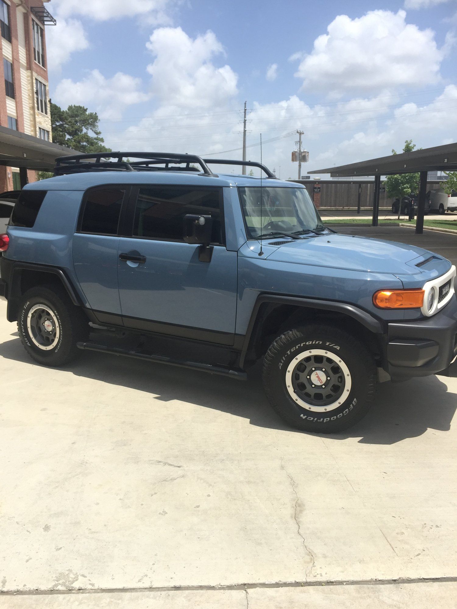 A blue toyota fj cruiser is parked in a parking lot.