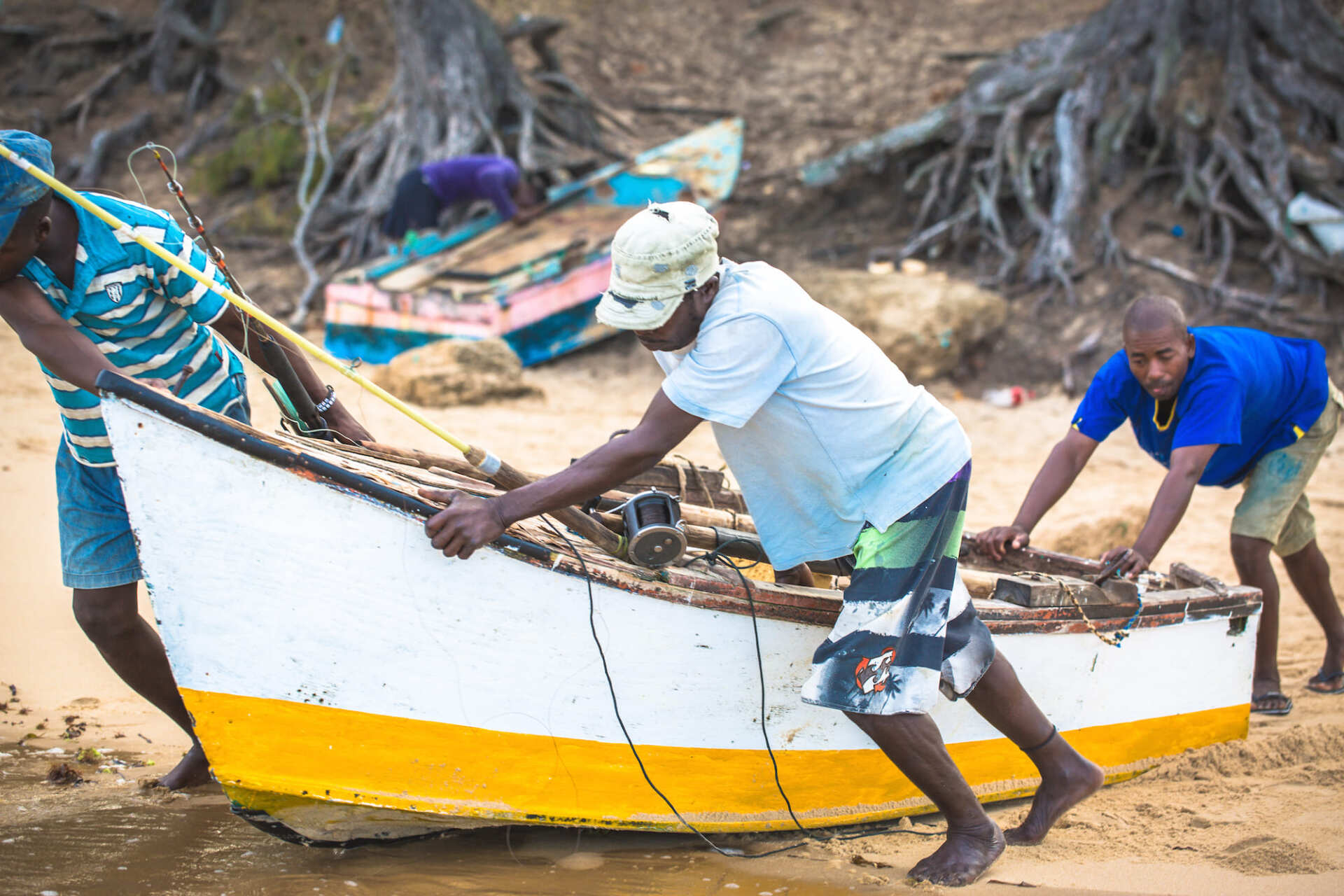 people pushing a boat on tofo beach