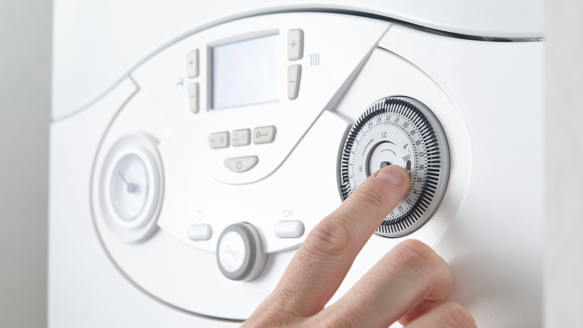 A person is adjusting a thermostat with their finger.