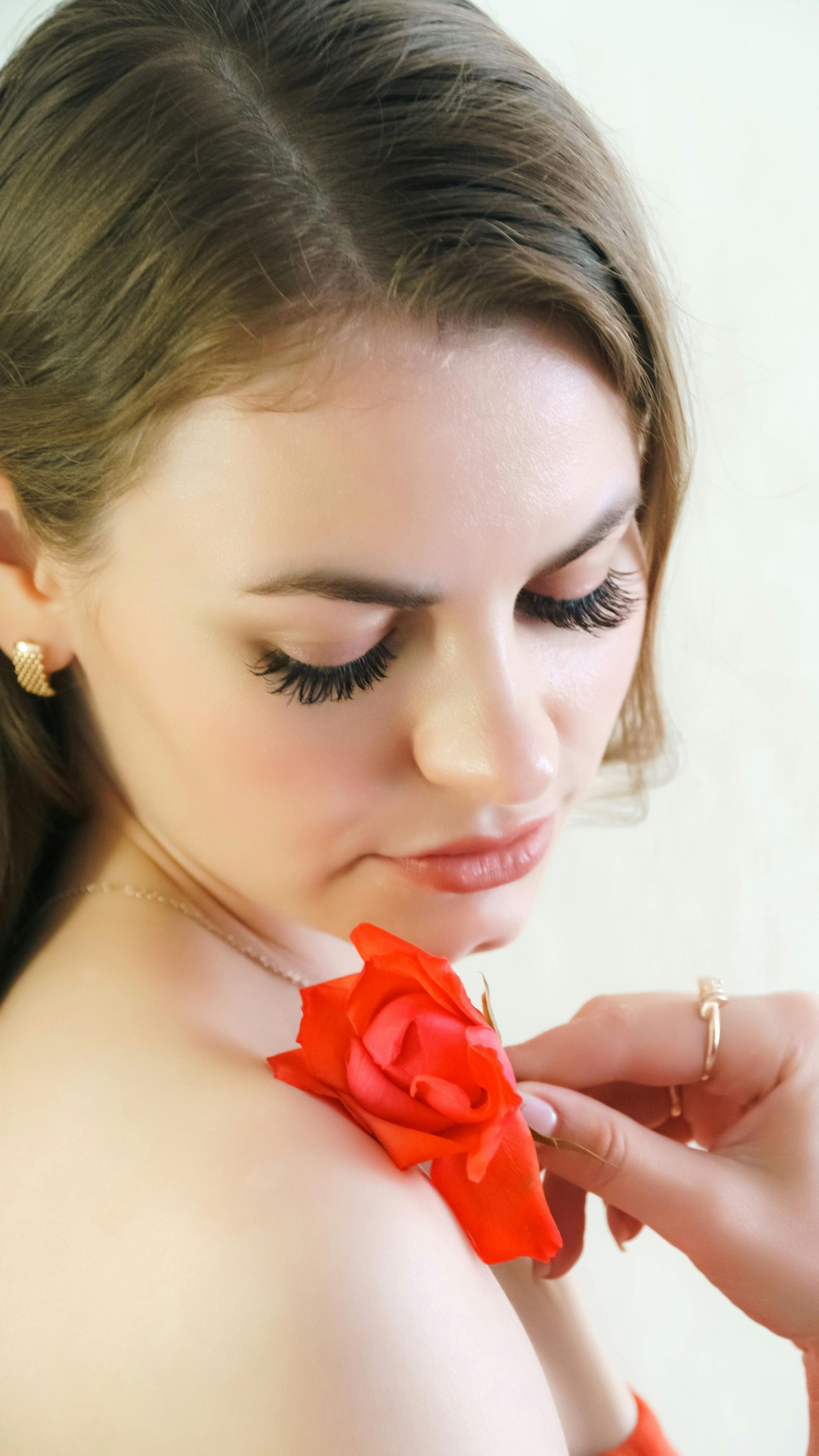 Person receiving eyebrow microblading, hands with pink gloves holding the tool.