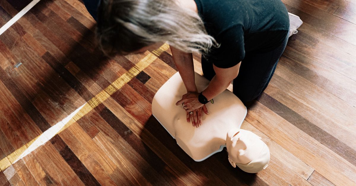 People learning CPR during first aid training in an office setting