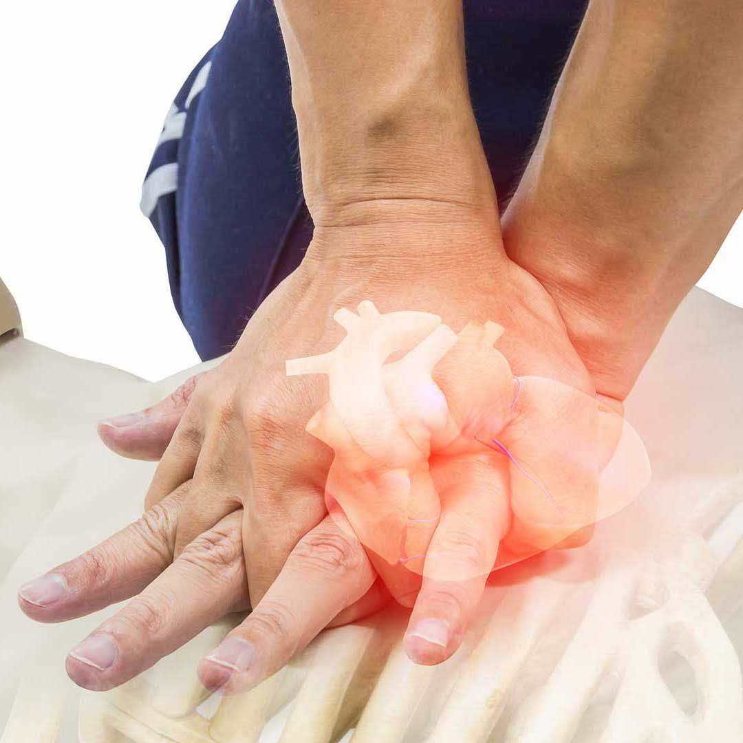 Hands performing CPR on a person; an overlay shows the heart and ribcage.