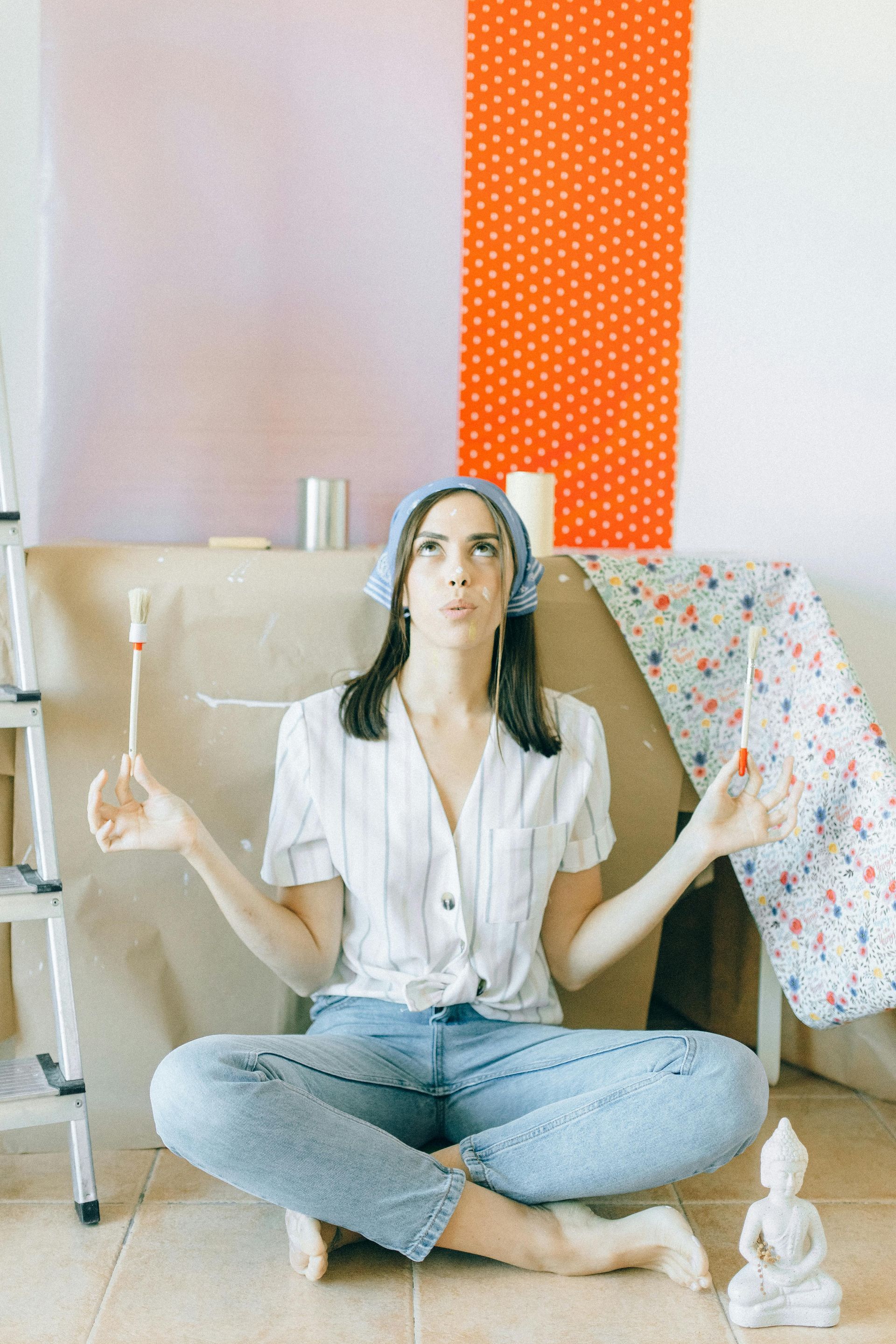 decorator holding up paintbrushes 