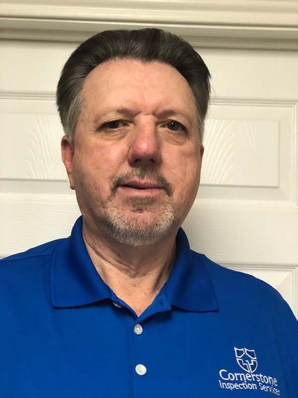 A man with a beard is wearing a blue polo shirt.