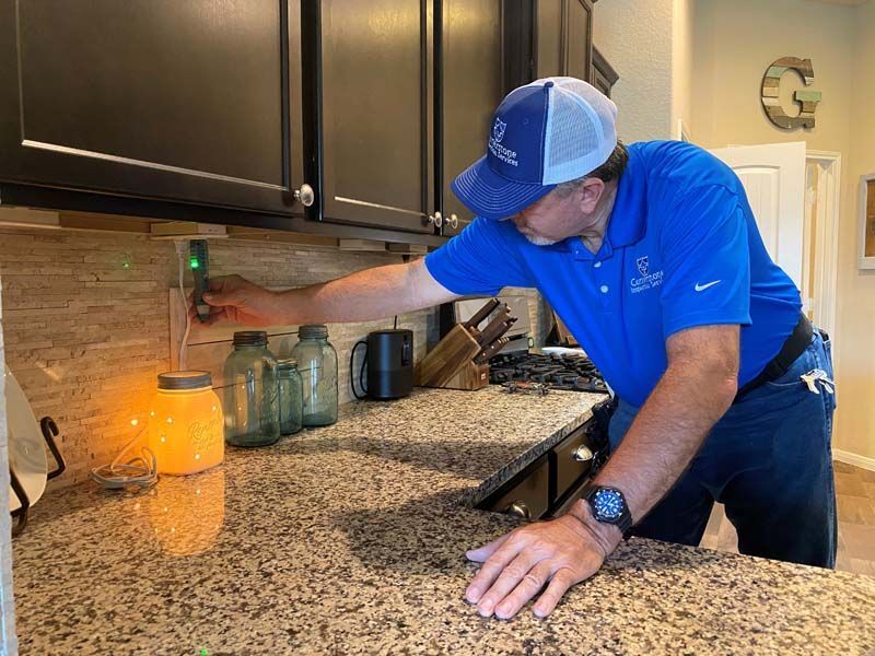 A man in a blue shirt is working on a kitchen counter.