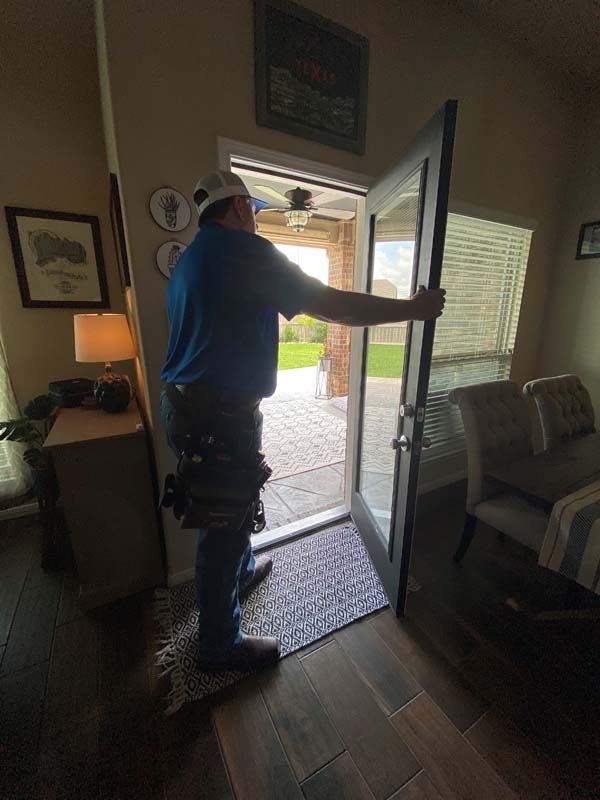 A man is opening a glass door in a living room.