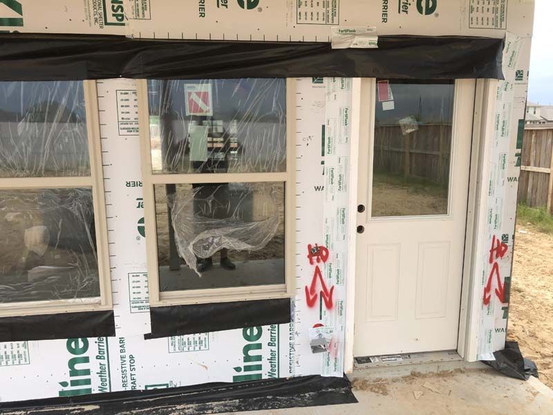 A house is being built with a lot of windows and a door