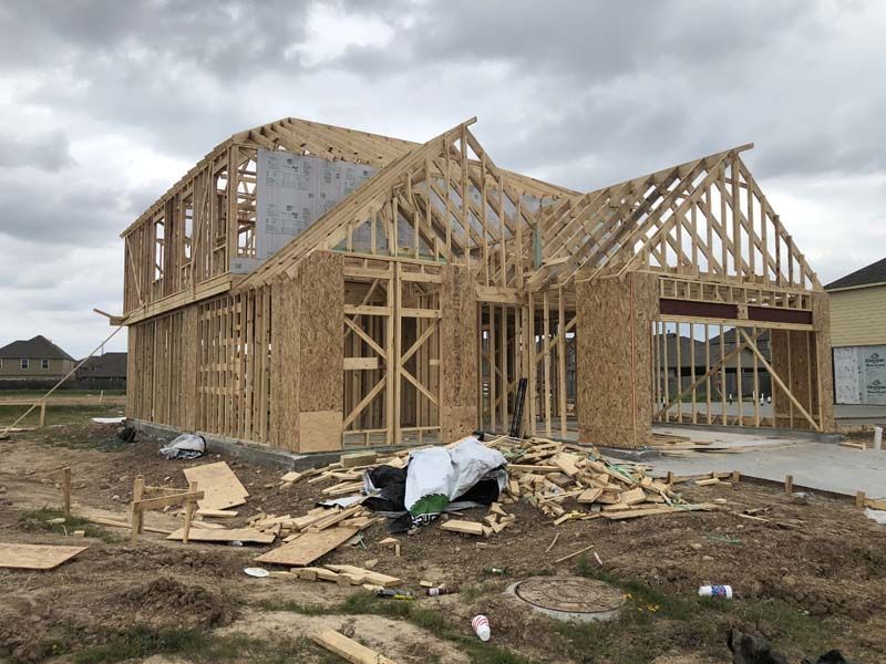 A house is being built in the middle of a field.