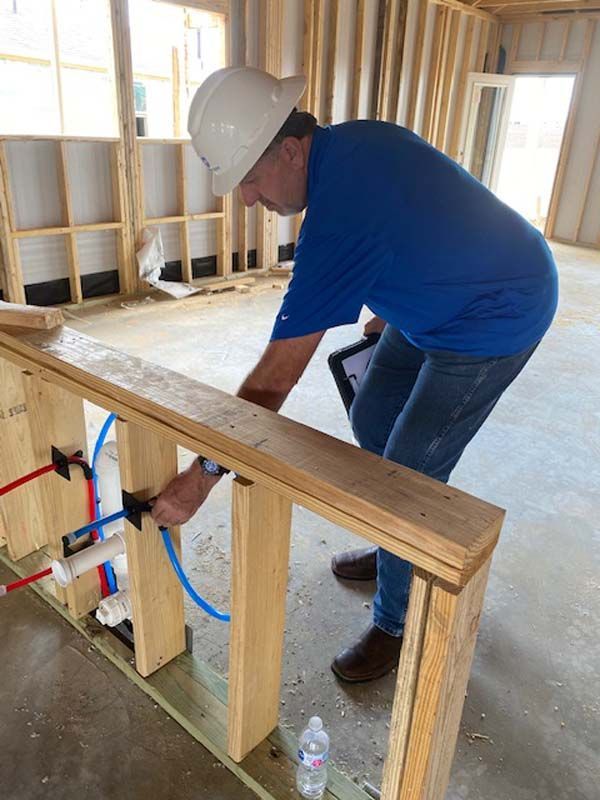 A man in a hard hat is working on a wooden wall.