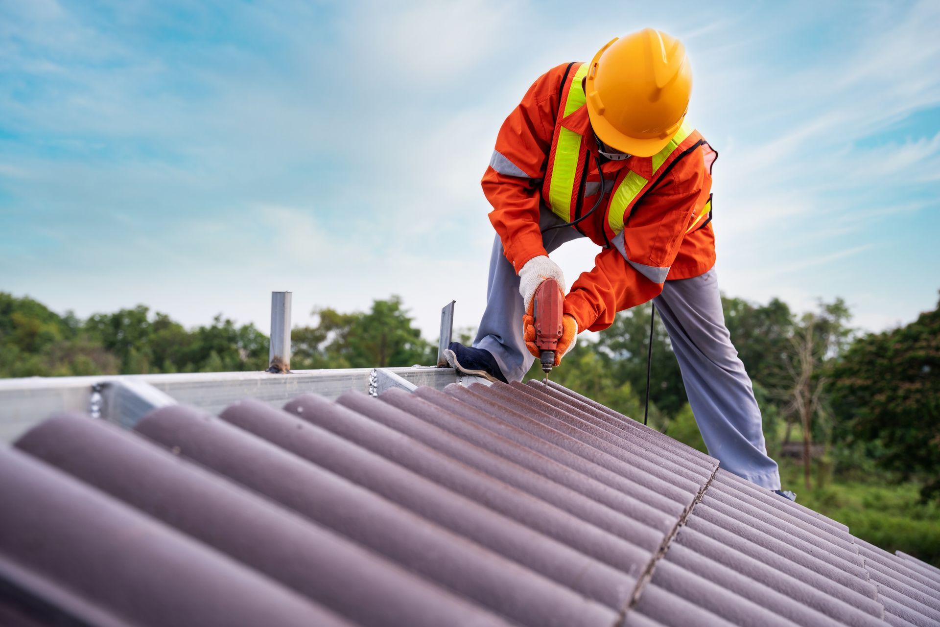 A man is working on a roof with a drill.