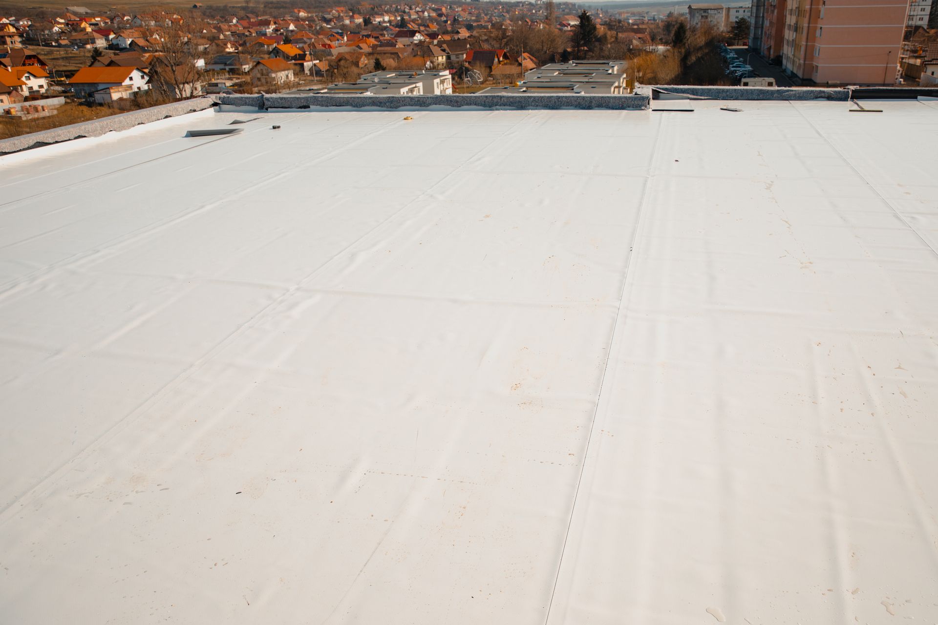 A white roof with a view of a city in the background.