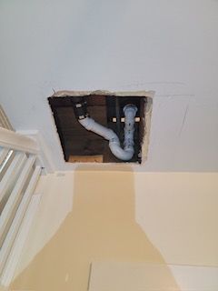 a bathroom sink is being installed in a hole in the ceiling .
