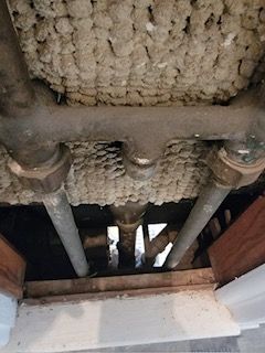 a bunch of pipes are hanging from the ceiling of a building .