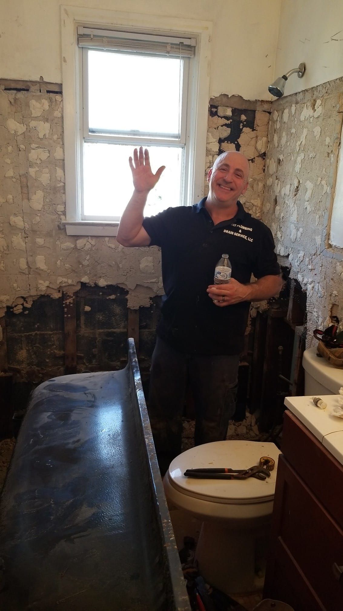 a man is standing in a bathroom next to a toilet .