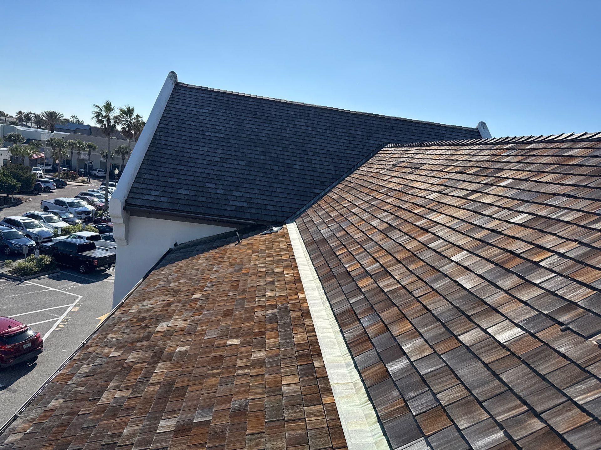 A roof with a lot of tiles on it and a parking lot in the background.