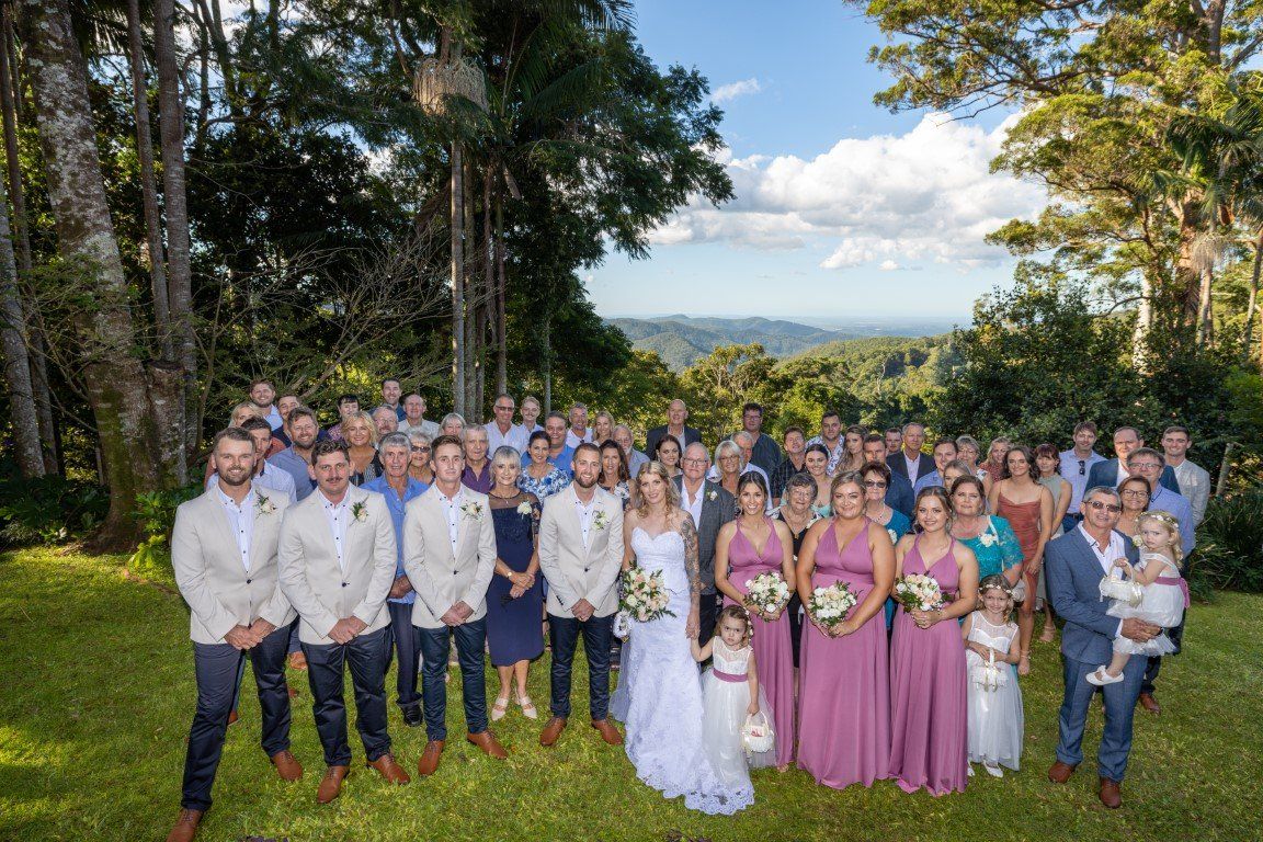 a large group of people are posing for a picture at a wedding .