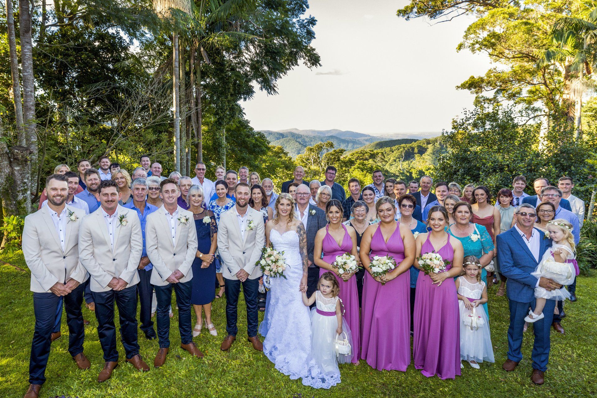 a large group of people are posing for a picture at a wedding .