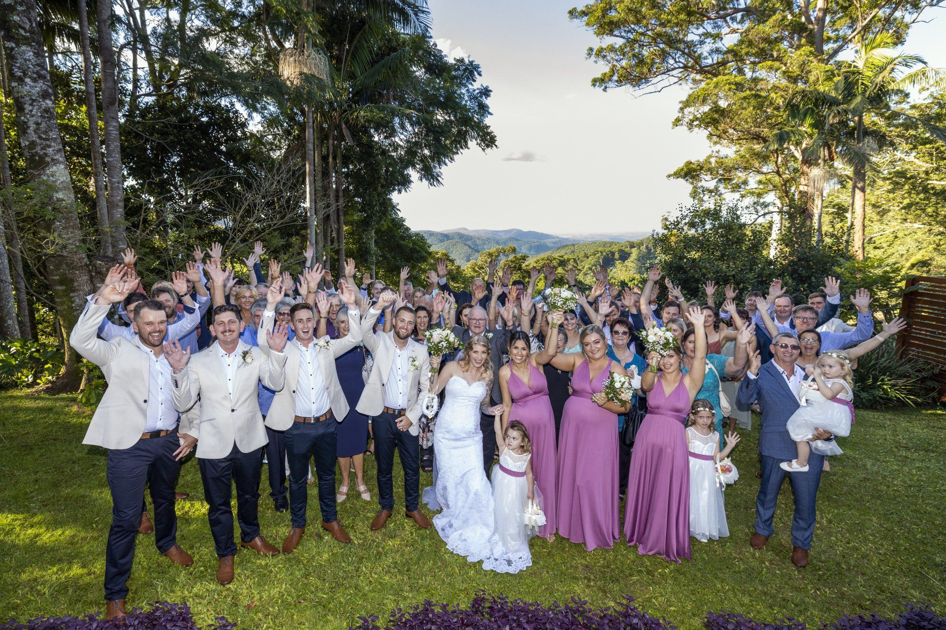 a large group of people are posing for a picture at a wedding .