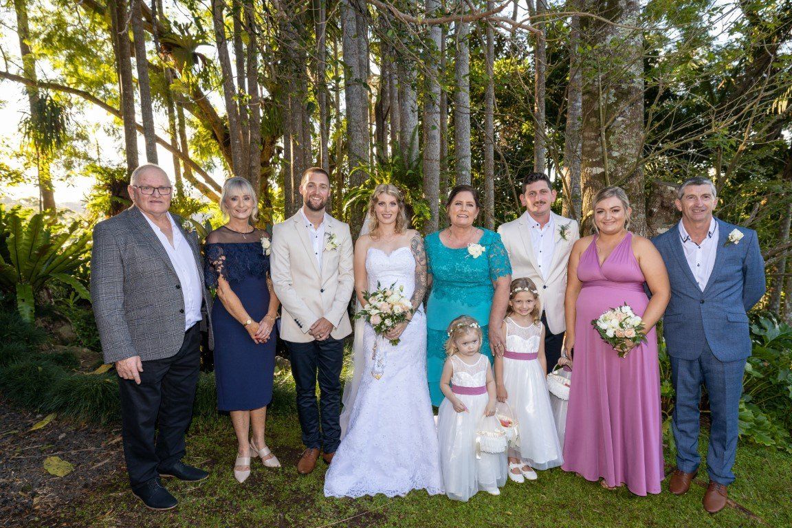 a bride and groom are posing for a picture with their wedding party .