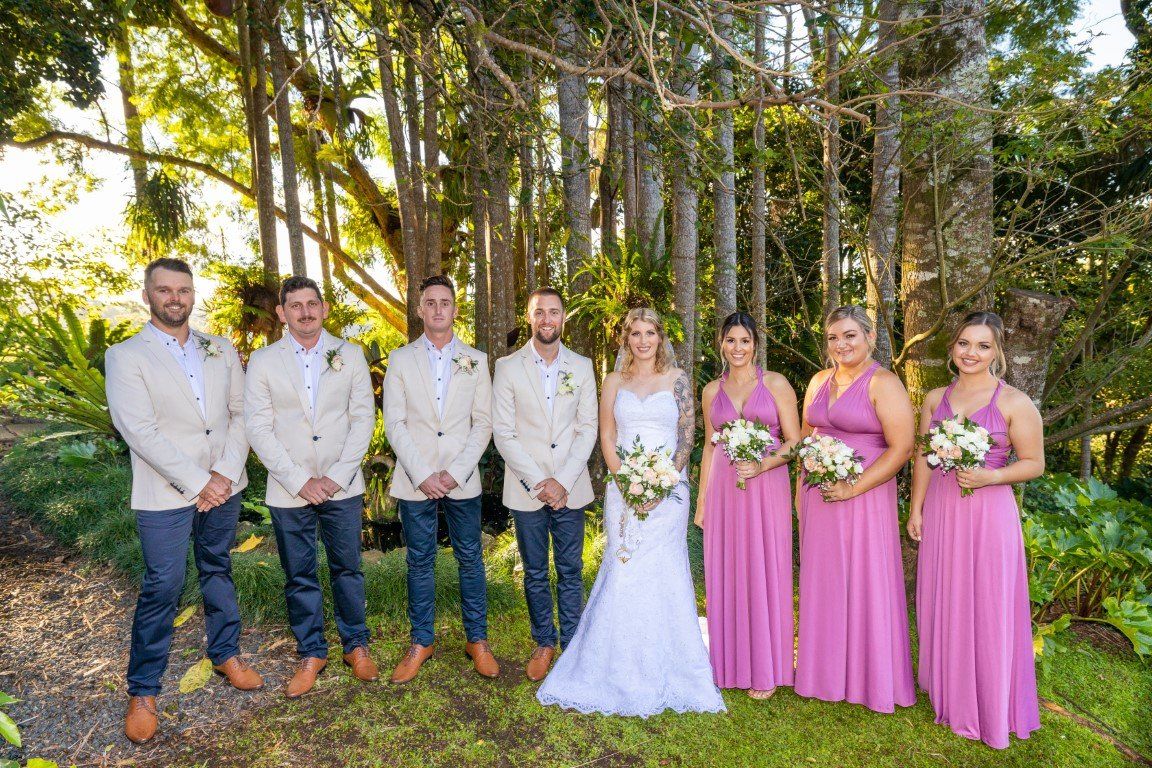 the bride and groom are posing for a picture with their wedding party .
