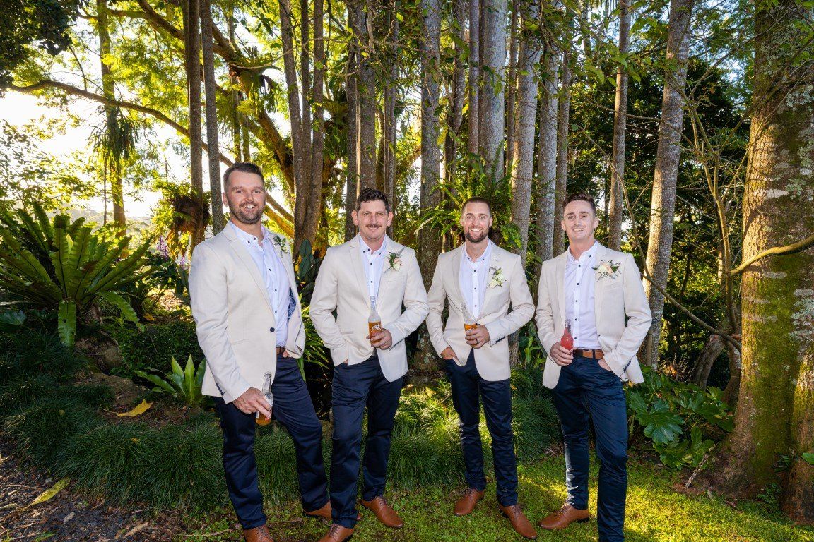 the groom and his groomsmen are posing for a picture in the woods .Kristin & Liam | Wedding at St Bernards