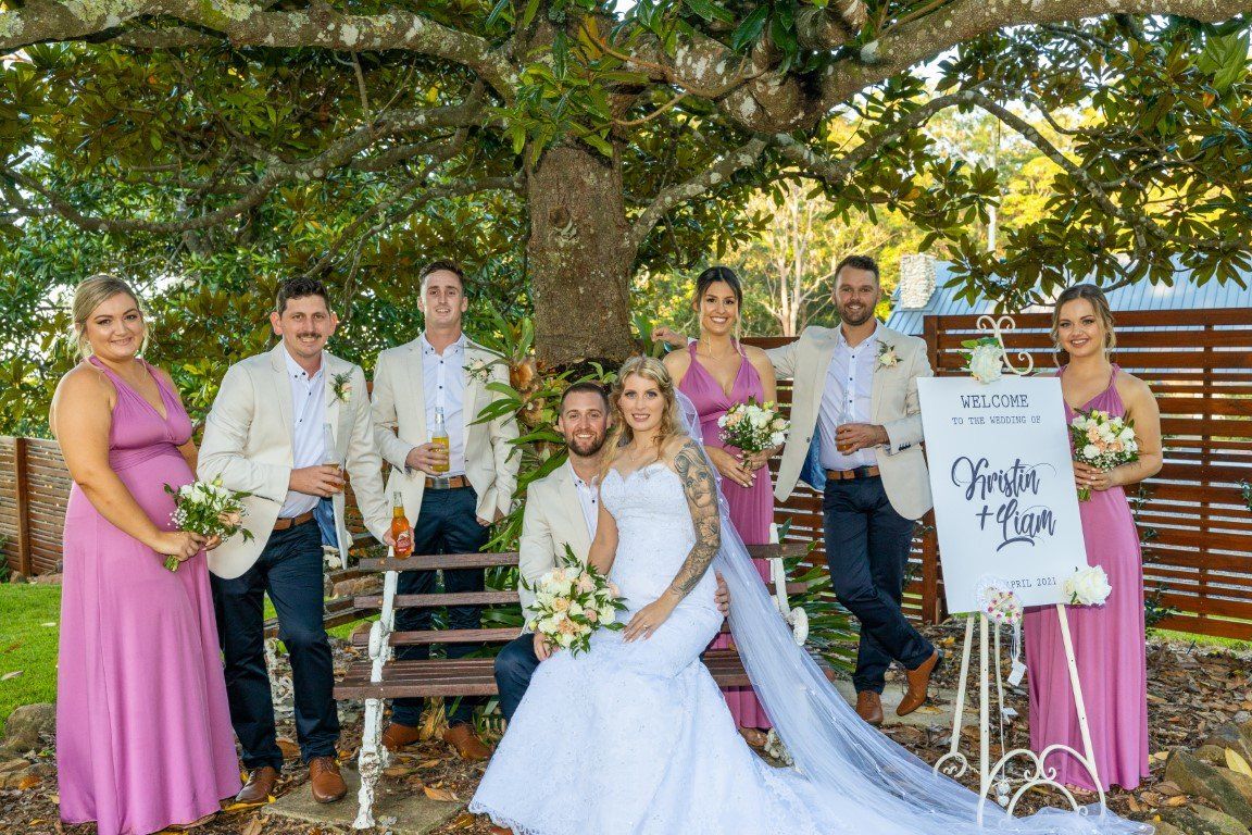 a bride and groom are posing for a picture with their wedding party .