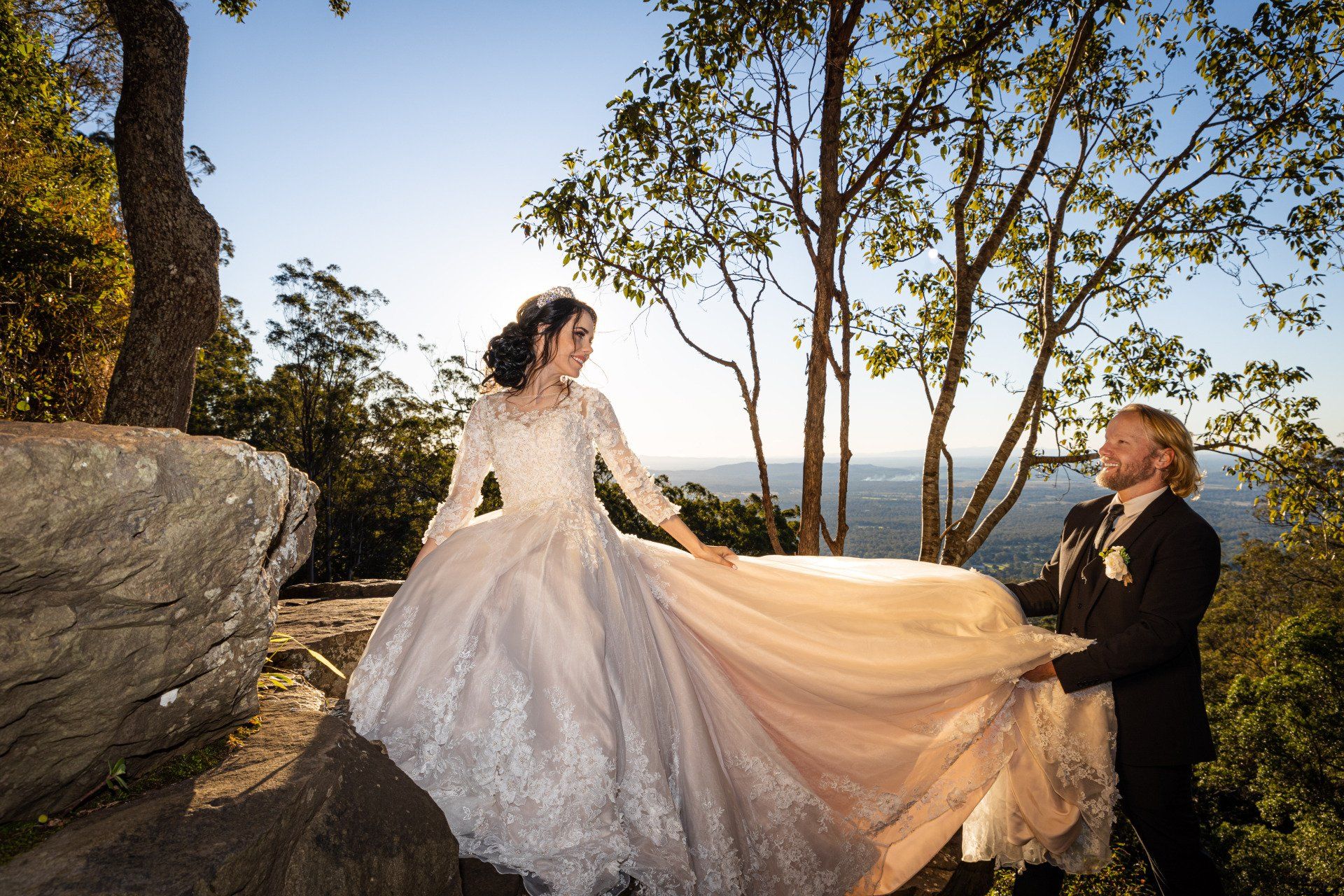 A bride and groom are posing for a picture on top of Tamborine Mountain