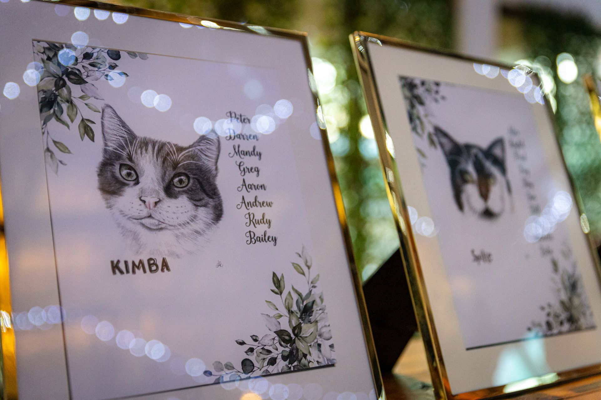 two framed pictures of a cat are sitting on a table .