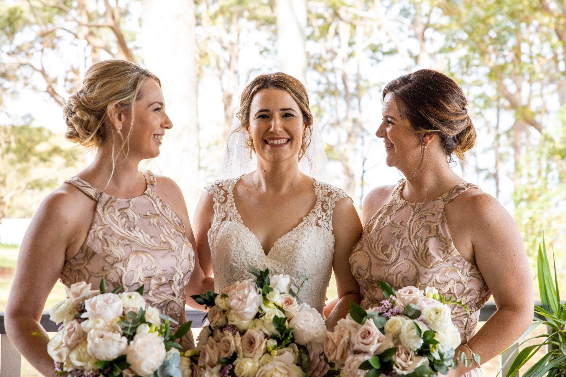 a bride and her two bridesmaids are posing for a picture .