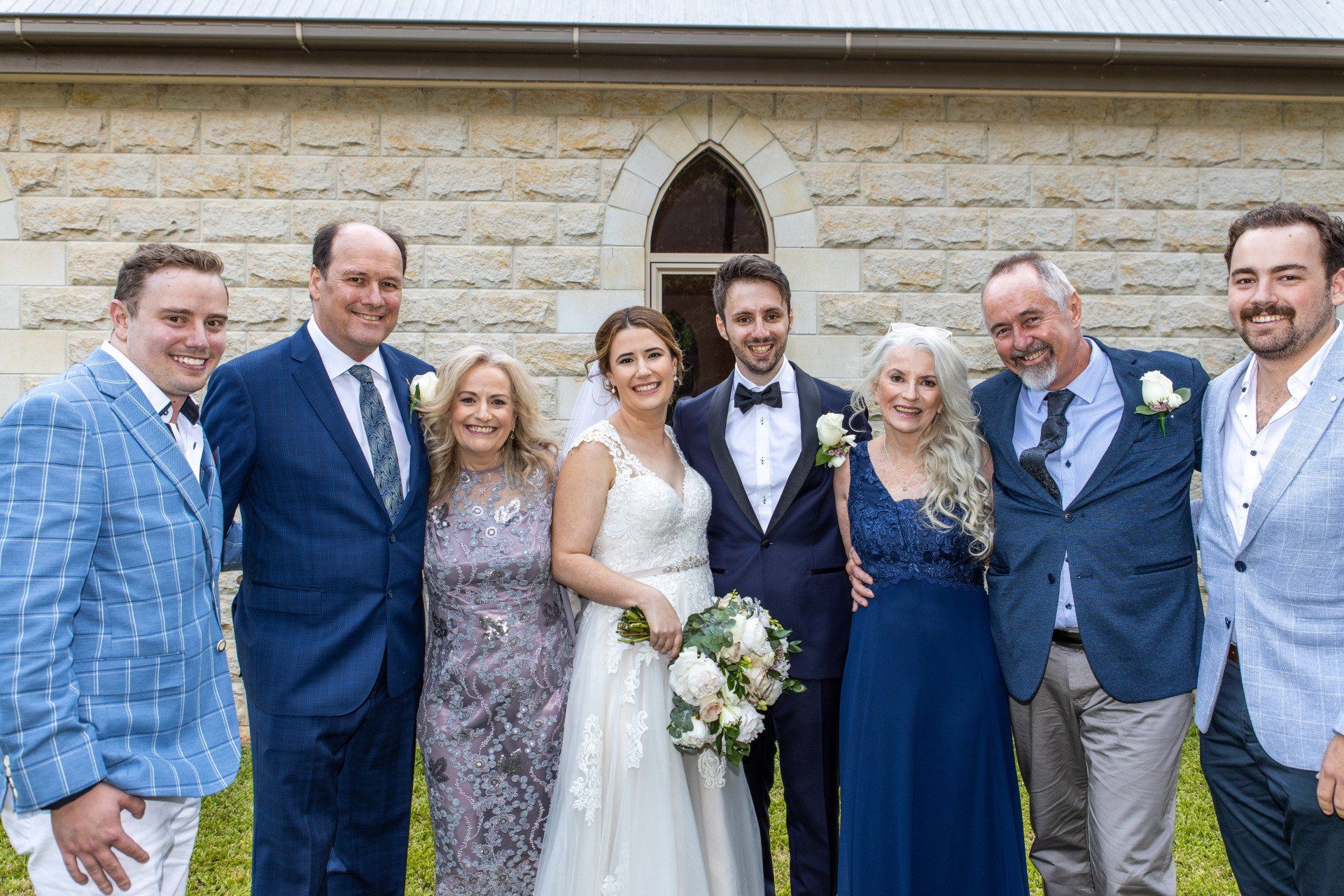 the bride and groom are posing for a picture with their family .
