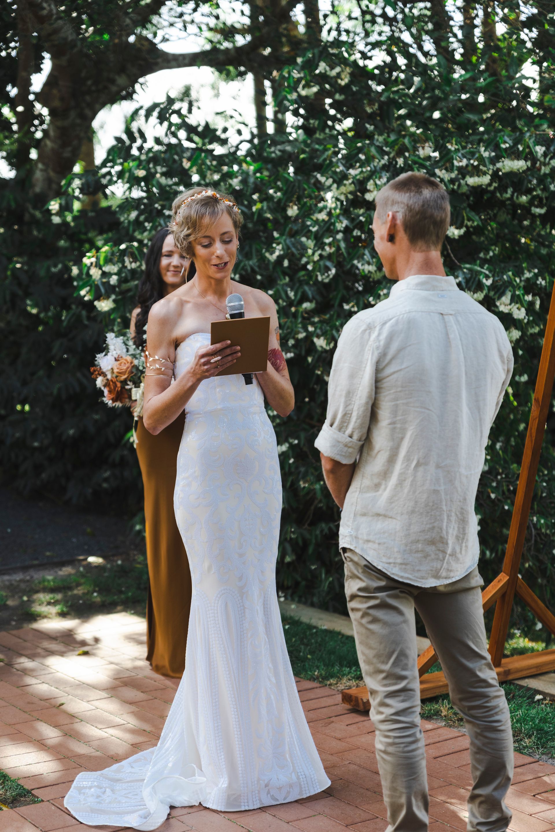 a woman in a white dress is standing next to a man in a white shirt .