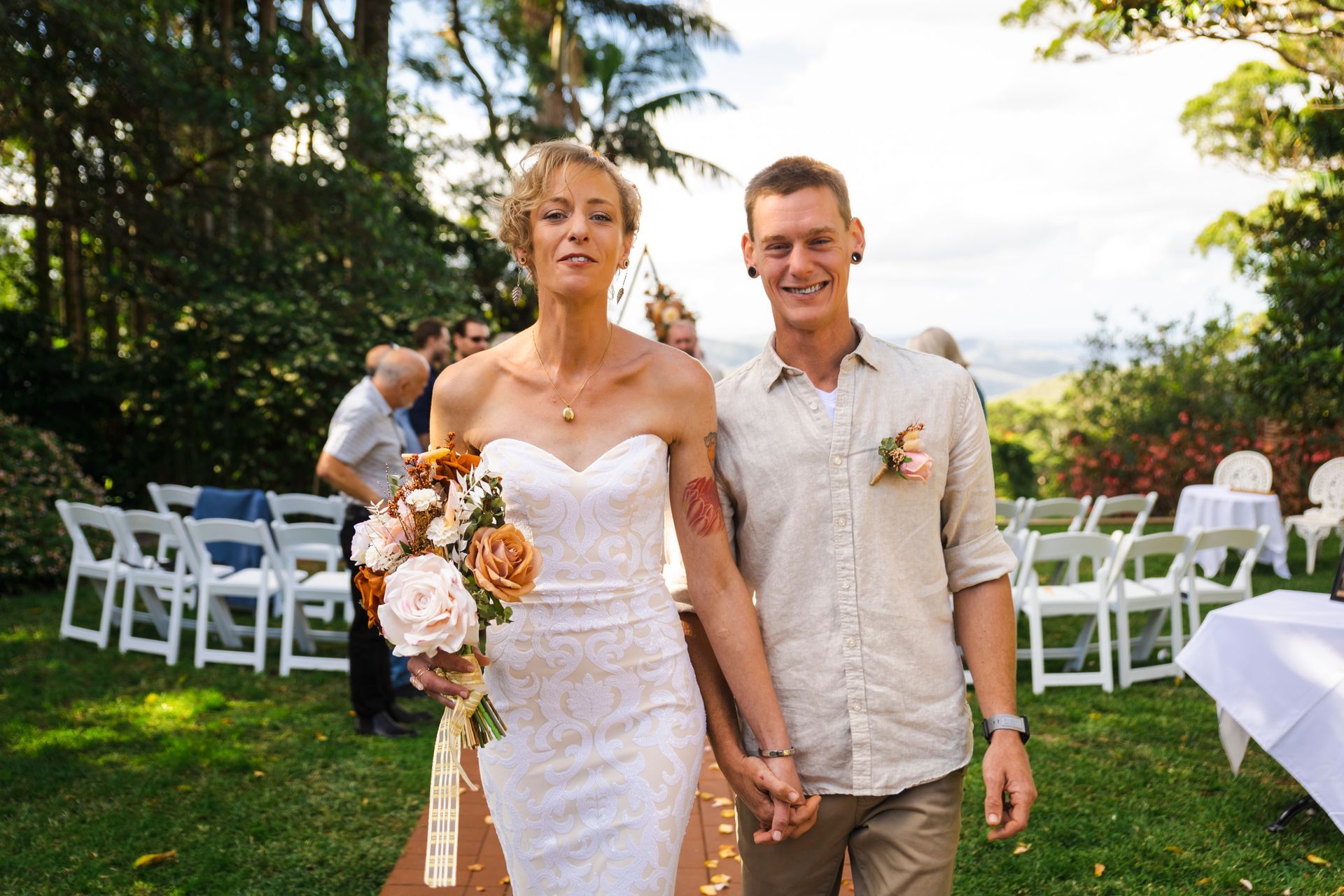a bride and groom are walking down the aisle at their wedding holding hands .