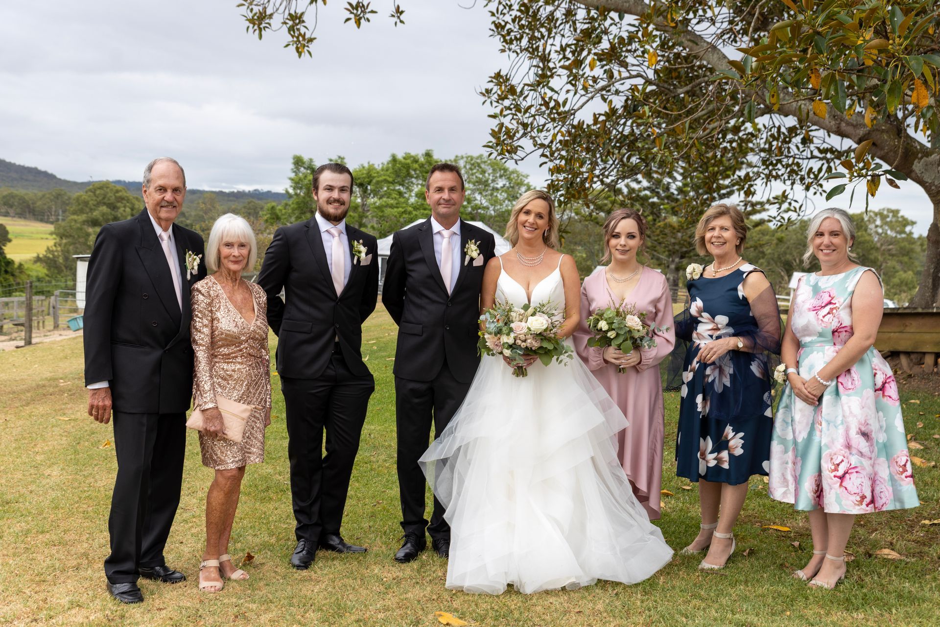 the bride and groom are posing for a picture with their family .