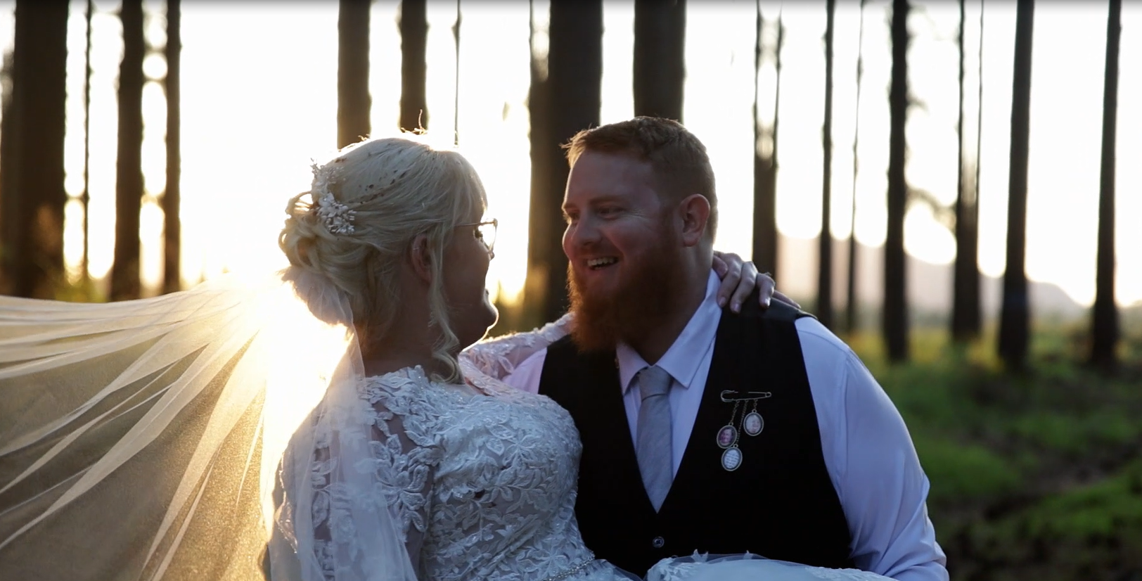 Hideaway Weddings Film - a bride and groom are posing for a picture in the woods .