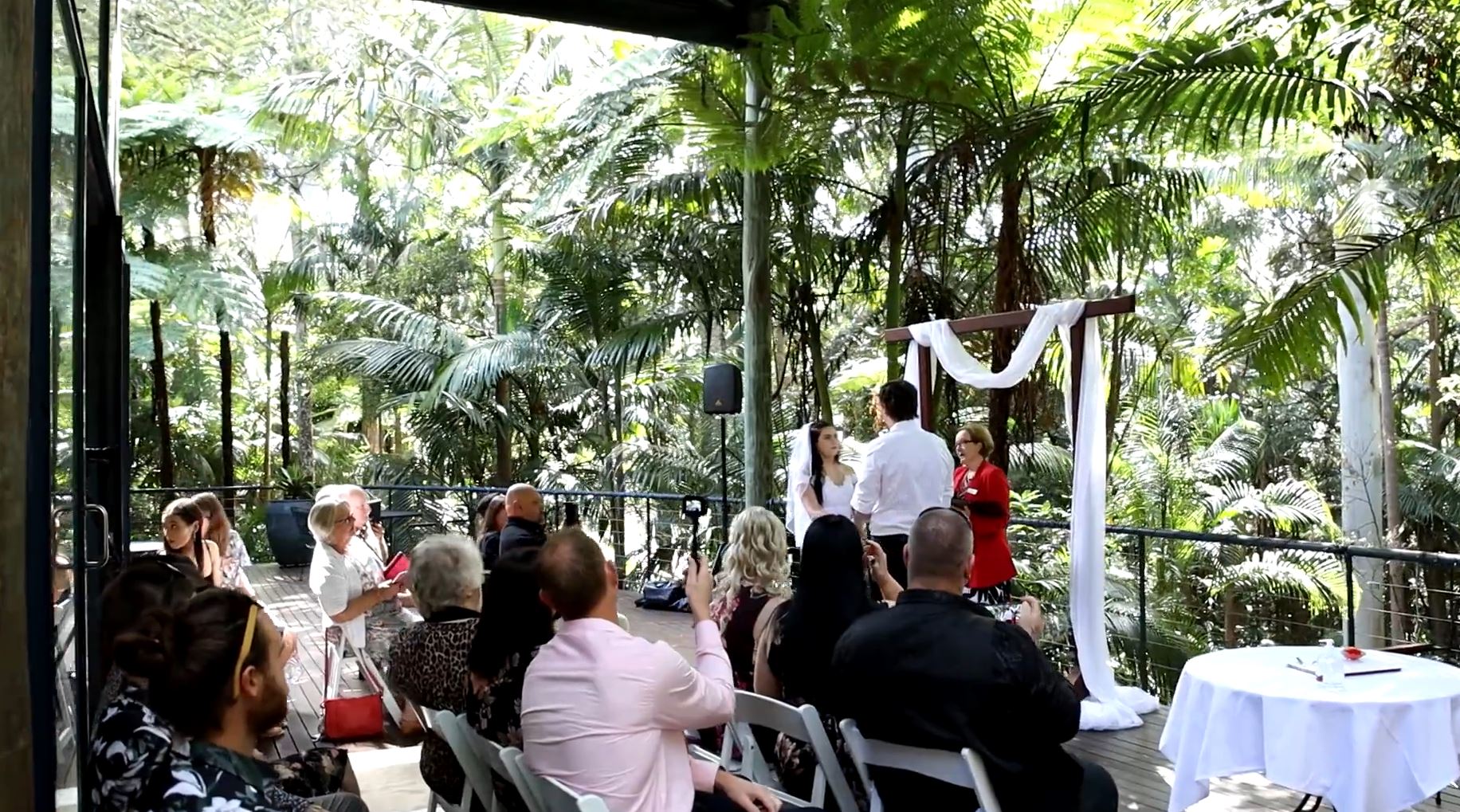 a group of people are sitting in chairs watching a wedding ceremony .