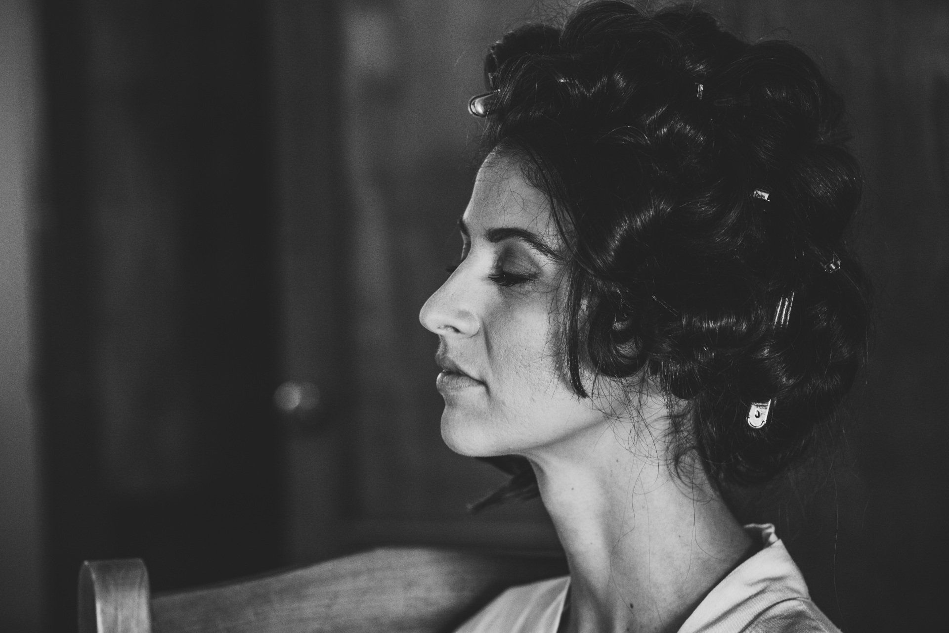 a black and white photo of a woman with curlers in her hair .