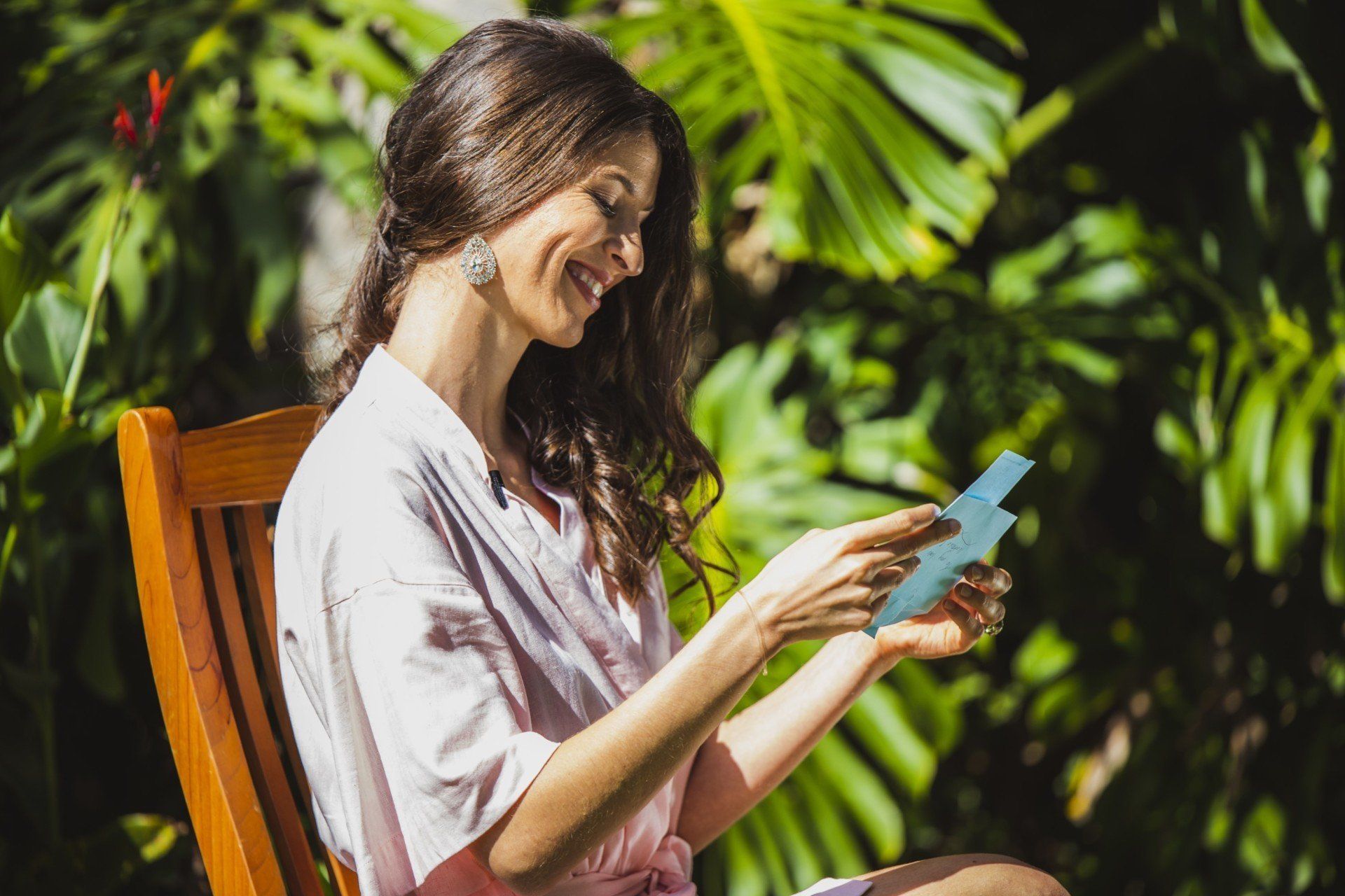 a woman is sitting in a chair reading a card .