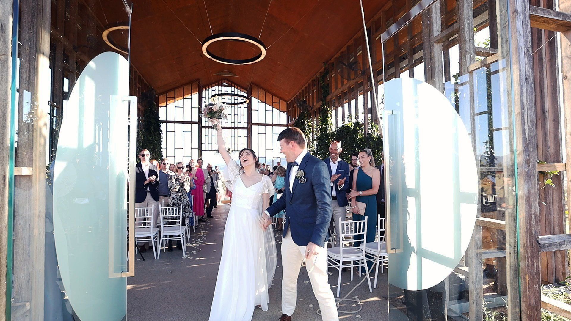 a bride and groom are walking down the aisle at their wedding .