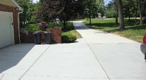 A car is parked in a driveway next to a garage.