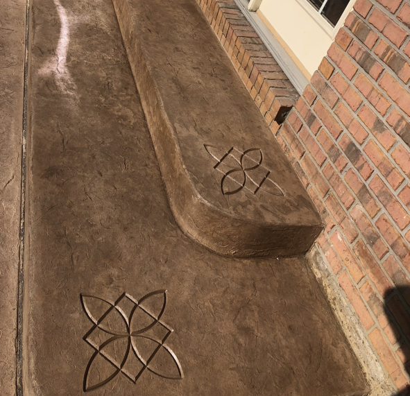 A brick wall with a concrete bench with the number 101 carved into it