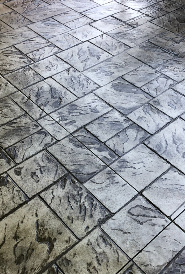 A close up of a brick floor with a pattern.