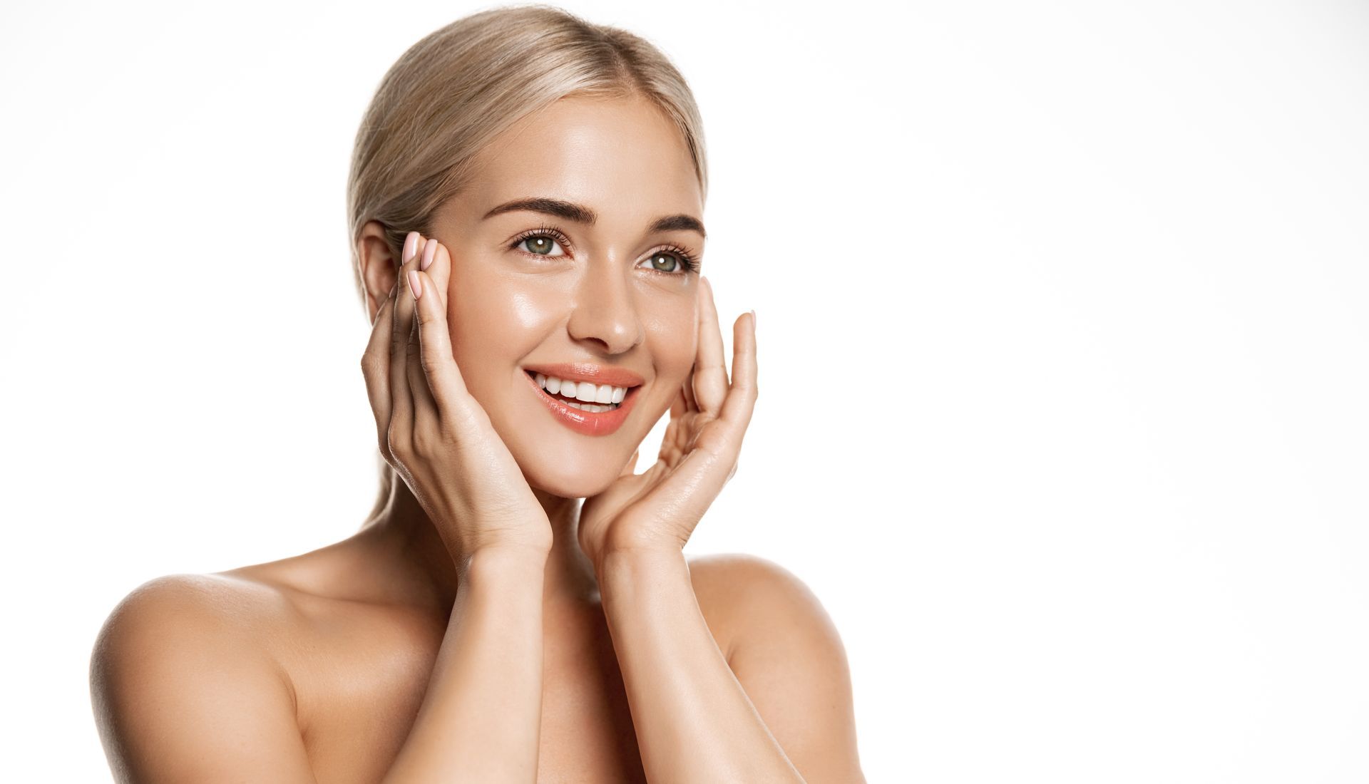 Smiling woman with hands on her face against a white background